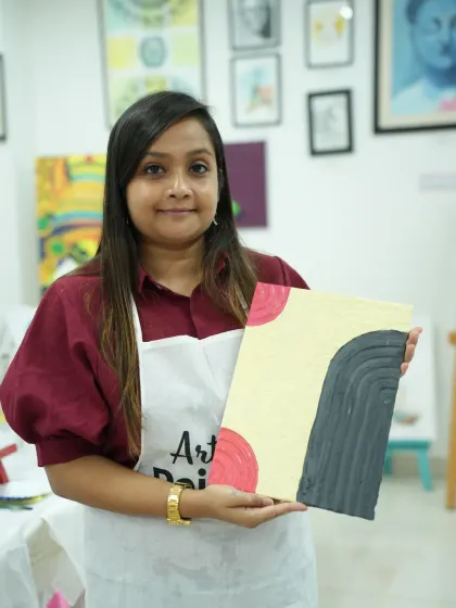 A participant with her finished abstract texture painting. The geometric shapes and patterns create a modern and stylish artwork.