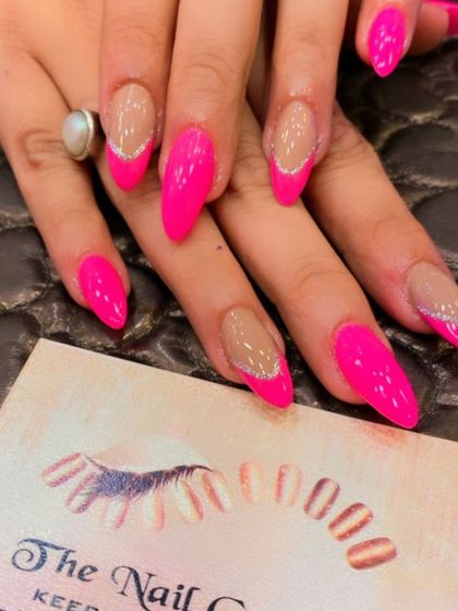 A duplicate of image 109, showing a modern design on long stiletto nails with hot pink tips and a silver glitter smile line.
