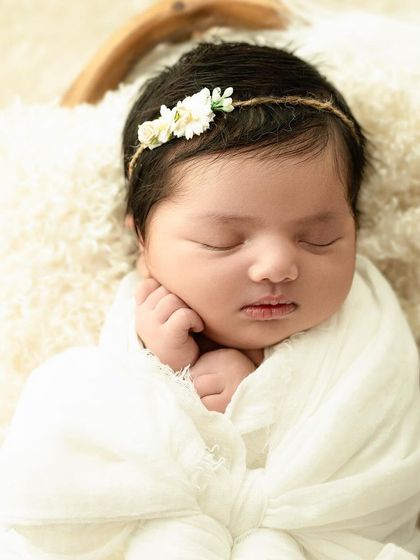 For the sweetest of smiles. A simple white swaddle and a delicate floral headband are perfect for capturing those fleeting, dreamy smiles.