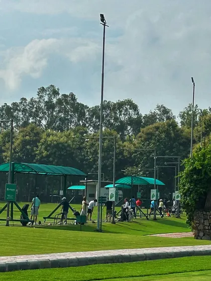 A wide shot of the driving range, showcasing the ample space and beautiful landscape that surrounds our practice facility.