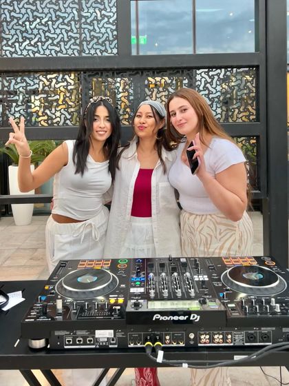 Sharing peace signs and good vibes behind the DJ deck.