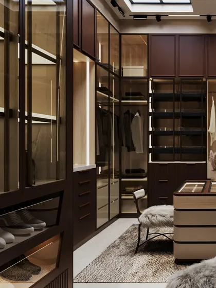 A detail of the glass-fronted wardrobes, which are internally lit to showcase the clothing and shoes. The design balances luxury with practical organization.