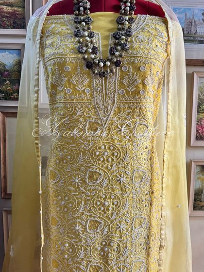 A full view of the yellow suit on a mannequin, showing its bright and sunny disposition.