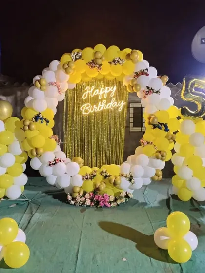 The same 5th birthday ring at night, with a golden fringe curtain and neon sign creating a sparkling effect.