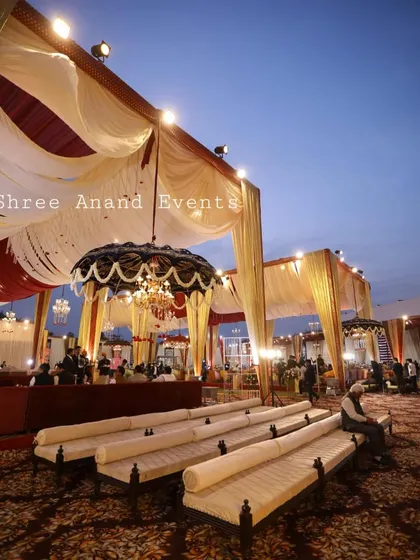 A low-angle shot of the guest seating area, emphasizing the grand scale of the draped canopy and the ornate hanging decor.