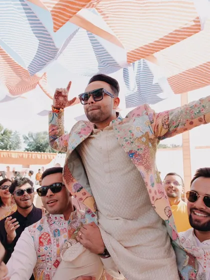 The groom makes a rockstar entrance on his friends' shoulders during the Haldi party.