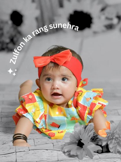 A color-splash effect highlights this adorable baby girl in a colorful outfit against a monochrome background. This creative editing style makes the portrait pop.