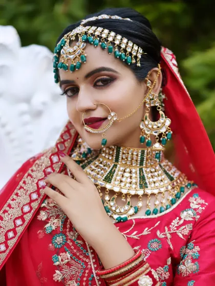 A stunning North Indian bridal look, complete with a vibrant red lehenga and intricate jewellery. I specialize in creating both traditional South Indian and glamorous North Indian bridal styles, ensuring every bride feels perfect on her big day.
