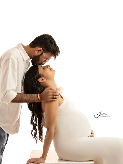A simple yet powerful pose showing the connection between the couple. The partner leans in from behind, creating a feeling of support and love in this clean, high-key shot.