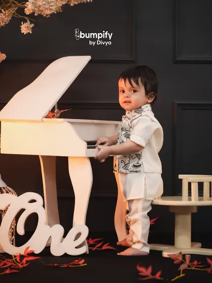 Standing tall! This little one is exploring the piano during his first birthday shoot, a perfect capture of his growing curiosity.