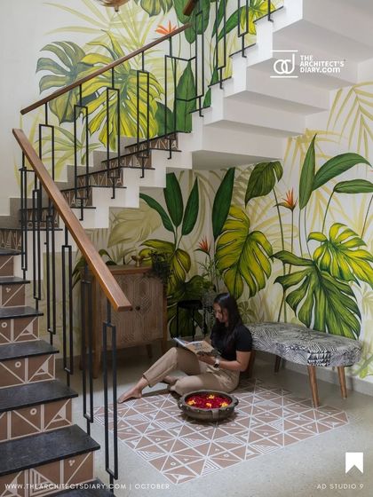 A publication feature of the staircase, highlighting the hand-painted mural and the cozy seating area underneath.