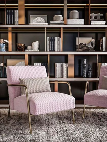 The Bliss Arm Chair, seen here in a sophisticated living space. Crafted with premium pink velvet and a sleek stainless steel frame, it's a true statement of comfort.