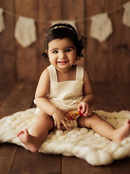 A full view of the setup, with the baby sitting confidently and smiling. These sessions are all about capturing their newfound independence.