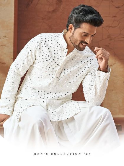 A white mirror-work kurta that speaks volumes. Paired with dhoti pants, this ensemble is a perfect blend of traditional celebration and modern sophistication.