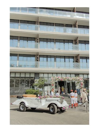 The groom's grand arrival in a beautifully decorated vintage car. This shot captures a touch of old-world charm and luxury at the Oxford Golf Resort.