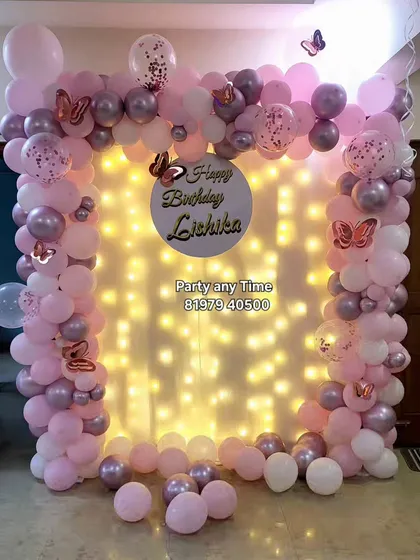 A closer view of the butterfly and fairy light backdrop. The pink and chrome balloons create a soft and elegant look.