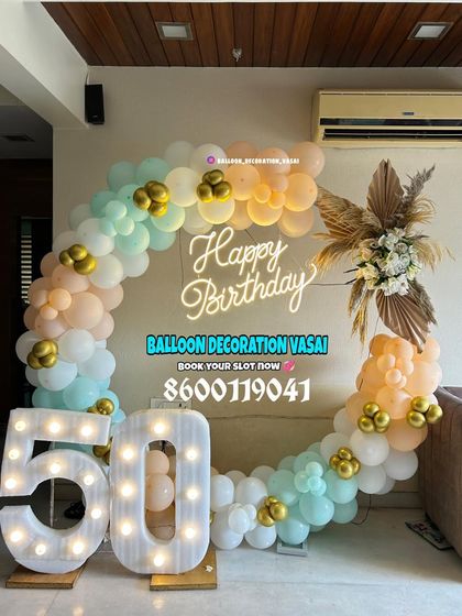 A pastel-themed 50th birthday celebration. The ring backdrop is decorated with mint, peach, and white balloons, paired with large marquee numbers.