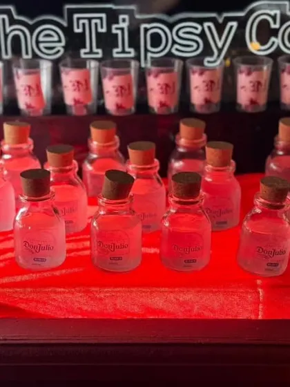 Another look at our custom-bottled Don Julio shots. The personalized labels and neat presentation on a red tablecloth make this a premium and well-organized shot station.