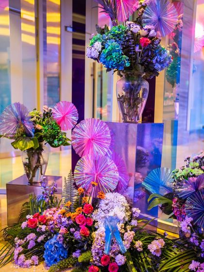 A close-up of the vibrant floral arrangements at the Sangeet entrance. We mixed colorful blooms with iridescent, fan-shaped accents to tie the floral design into the modern theme.