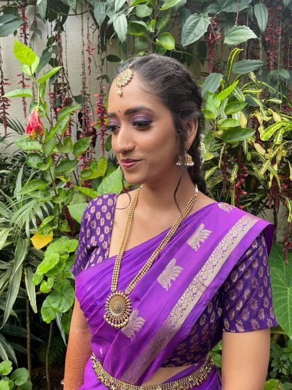 Dr. Rakshitha's third look for her ring ceremony, featuring a vibrant purple saree. The dramatic eye makeup still works beautifully, showcasing the versatility of the look.