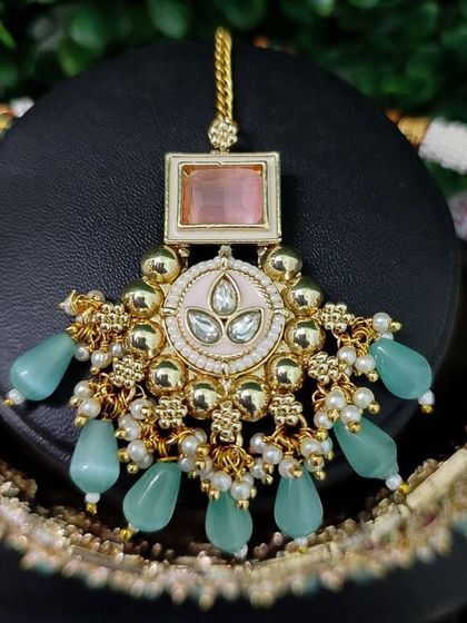 The maang tikka for this set, featuring the same lovely pastel color palette.