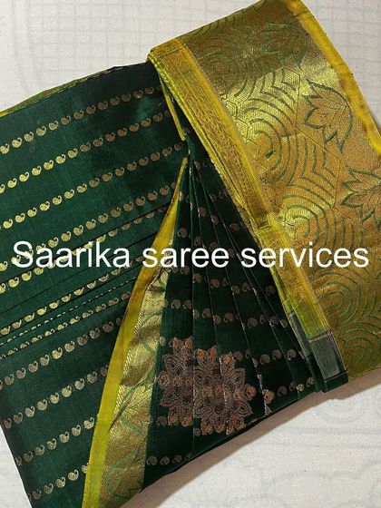 This dark green saree with gold stripes and motifs is now perfectly pleated and ready for a festive occasion.