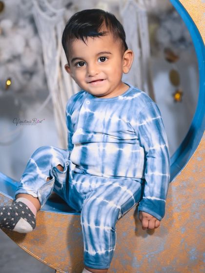 A happy toddler enjoying the celestial moon set. The soft, cloud-like floor is perfect for babies who are sitting or crawling, ensuring they are comfortable throughout the shoot.