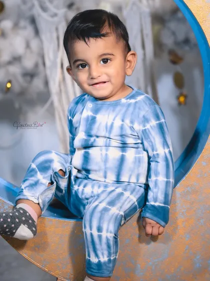 A happy toddler enjoying the celestial moon set. The soft, cloud-like floor is perfect for babies who are sitting or crawling, ensuring they are comfortable throughout the shoot.