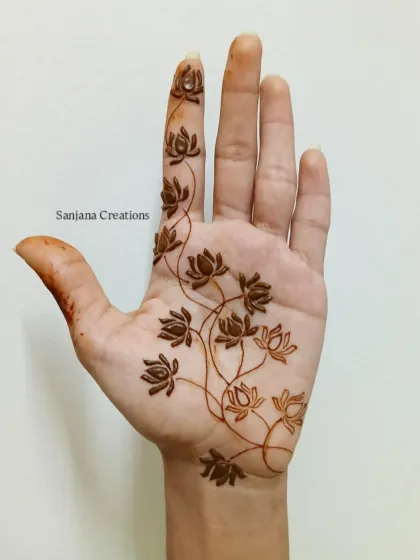 Here is the beautiful result of a fresh henna application. This design features a delicate lotus vine climbing up the palm, an elegant and modern take on traditional motifs. We focus on achieving this kind of clean linework and balanced composition in my classes.