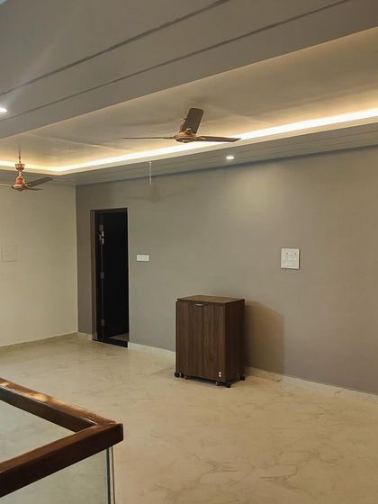 A minimalist upper-floor lounge area with clean lines and neutral tones. The recessed ceiling lighting provides a soft, even glow, creating a calm and versatile space.
