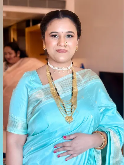 A close-up of her makeup, featuring a subtle green shimmer on the eyelid that beautifully picks up the color of her saree.