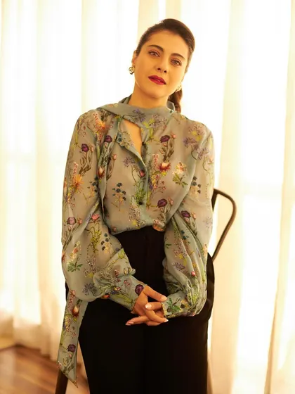 A full shot of the blouse paired with black trousers, creating a timeless and elegant ensemble for movie promotions.