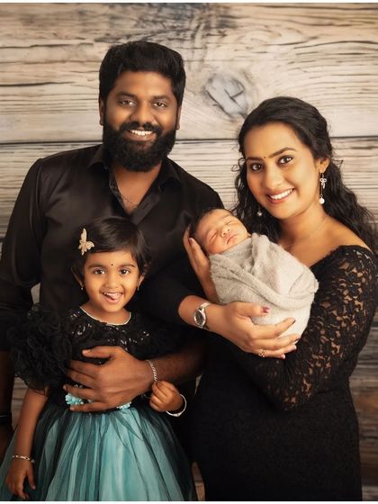 A classic family portrait with a newborn. The family is dressed in coordinating black outfits, creating a timeless and elegant look as they welcome their newest addition.