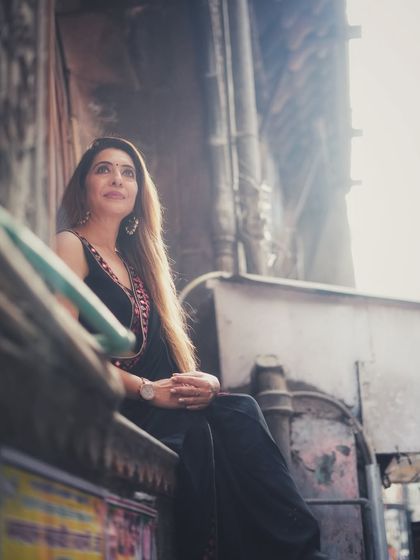 A low angle shot that uses the surrounding architecture to create a unique frame. Her upward glance and the soft lighting give this saree portrait a dreamy, hopeful quality.