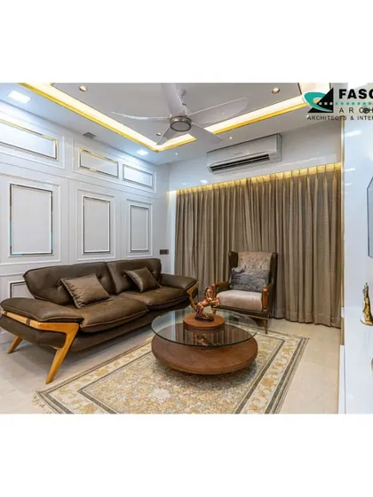 This living room in Seawoods is a study in understated elegance. A comfortable brown sofa is paired with classic white wall paneling with gold trim, creating a warm, bright, and sophisticated space.