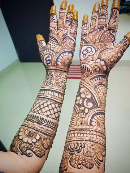 The full arm view of the "S" initial engagement mehandi, showing how the design flows from the palm to the forearm.