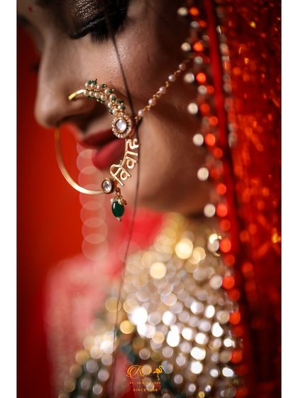 A creative close-up of a bride's custom nose ring, which has the word "Vivaah" (Wedding) inscribed on it.