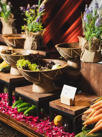 A "farmer's market" themed buffet setup, with fresh vegetables and rustic bowls creating an atmosphere of natural abundance. This concept highlights our commitment to using fresh, high quality produce.
