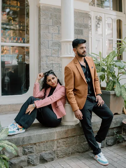 A stylish couple poses against a classic urban building in Mumbai. This image showcases a modern, chic approach to an urban couple shoot, blending fashion-forward posing with architectural backdrops.