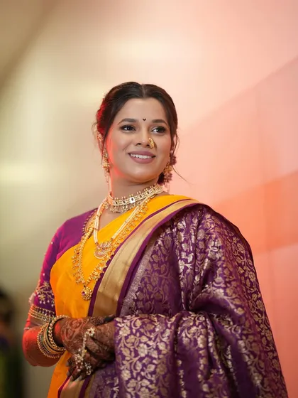 A classic portrait of a smiling bride. Her soft glam makeup and traditional attire create a timeless and elegant look.