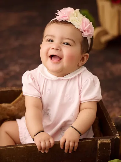 Sometimes the simplest moments are the most precious. We focus on capturing your baby's genuine expressions and budding personality, like this infectious, happy laugh.