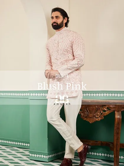 A stylized shot of the blush pink kurta, highlighting its unique color and intricate embroidery.