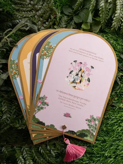 A fanned-out display of beautifully illustrated wedding inserts. The styling against a background of green leaves gives a fresh, organic feel to the stationery.