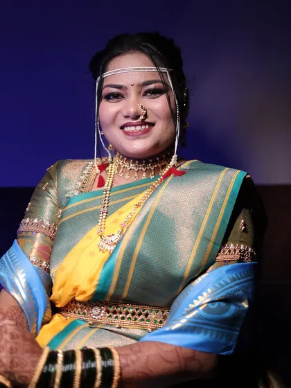 A portrait of a bride in a unique yellow and grey-green Nauvari. The makeup is kept elegant to complement the saree, with a focus on defined eyes and a bold lip.