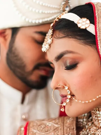 An intimate close-up with foreheads touching. This shot is full of emotion and highlights the bride's beautiful nose ring and makeup.