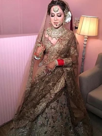 A classy and graceful bridal look. This bride chose a heavy kundan and emerald set that adds a touch of vintage charm to her golden lehenga.