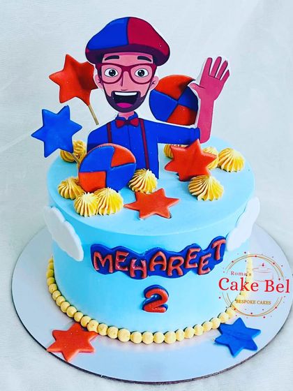 A fun Blippi-themed cake for a curious two-year-old. The bright orange and blue colors, stars, and cheerful Blippi topper make this a playful centerpiece for any toddler's party.