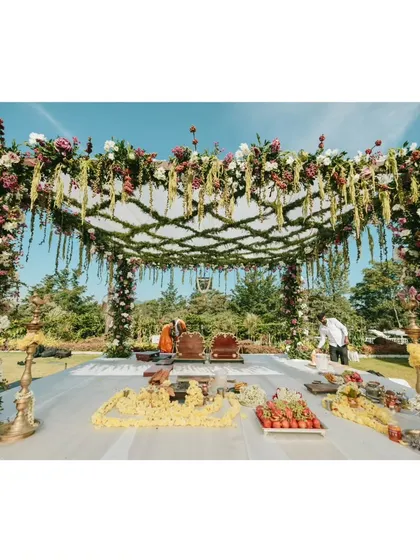 A full view of the unique mandap, where the ceiling is a lattice of fresh jasmine and the structure is adorned with locally sourced coffee berries from the groom's own plantation.