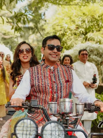 A cool shot of the couple enjoying their grand Haldi entrance. The sunglasses and relaxed vibe are perfect for a fun daytime event at a destination like Goa.