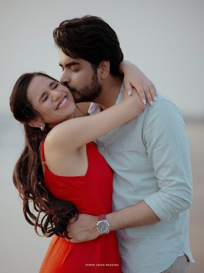 A sweet kiss for Keerthi from Arun on the beach. This classic romantic shot is a beautiful way to capture their love.